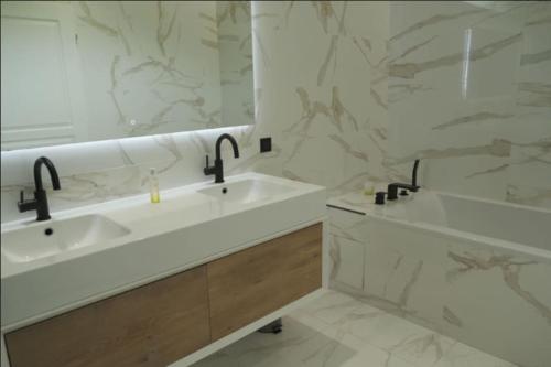 a white bathroom with a sink and a mirror at Maison d'architecte pour les JO in Saint-Hilarion