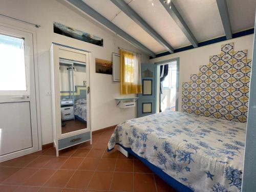 サン・ヴィート・ロ・カーポにあるSan Vito Katia Vacanzeのベッドルーム(ベッド1台、鏡付)