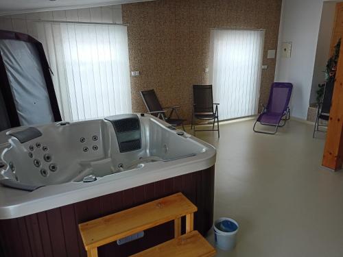 a bath tub in a room with purple chairs at Hotel Koloniál Skalité in Skalité