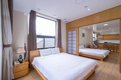 - une chambre avec 2 lits et une grande fenêtre dans l'établissement Cindy Hotel & Apartments - Khách Sạn Căn Hộ ở Trung Tâm TP Hải Phòng, à Hai Phong