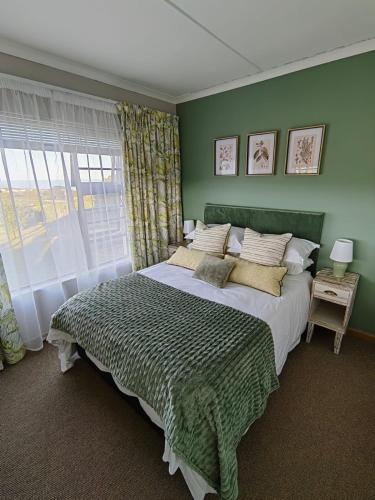 a bedroom with a large bed and a window at The Nightingale in Groot Brak Rivier