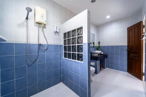 a blue bathroom with a shower and a toilet at Siam Court Hotel and Resort in Bang Sare