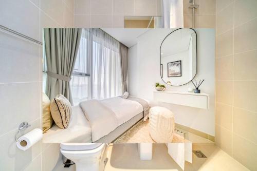 a bathroom with a bed and a toilet and a mirror at Livbnb - Elegant 3BR+Maid, Sea View in Bluewaters in Dubai