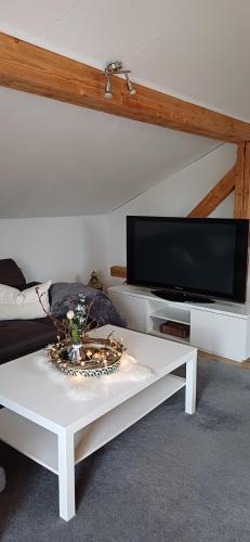 ein Wohnzimmer mit einem weißen Couchtisch und einem Flachbild-TV in der Unterkunft fowo-mangfalltal in Bruckmühl