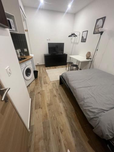 um quarto com uma cama, uma secretária e uma mesa em studio neuf rue de saint denis (colombes) em Colombes