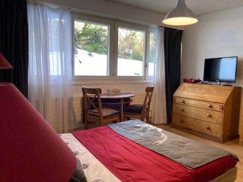 - une chambre avec un lit, une table et une fenêtre dans l'établissement Cosy studio, à Crans-Montana