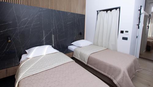 two beds in a room with a black wall at A Heritage Split in Split