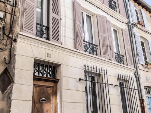 - un bâtiment avec une porte et des fenêtres en bois dans l'établissement La Demoiselle, à Avignon