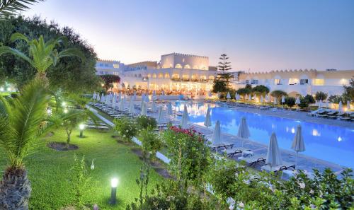 a resort with a large swimming pool with umbrellas at Platanista Hotel in Kos Town