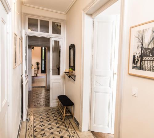 korytarz z białymi drzwiami i podłogą wyłożoną kafelkami w obiekcie La Demoiselle w Awinionie