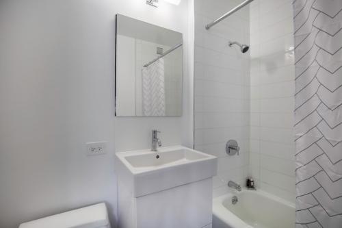 a white bathroom with a sink and a mirror at Theater District Studio w Indoor pool NYC-142 in New York