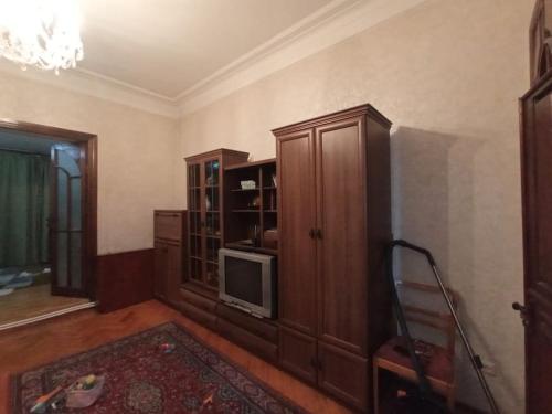 uma sala de estar com uma televisão e um armário em Квартира в Баку в тихом дворе em Baku