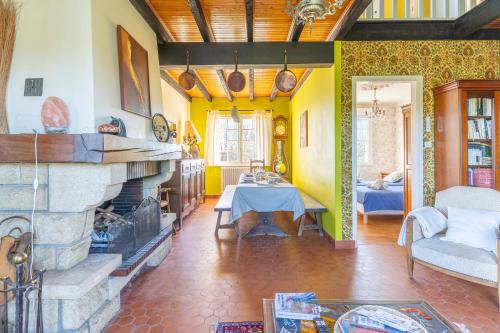 un salon avec une cheminée et une table dans l'établissement Ty Ar Bleiz Gwenn - La maison du Loup Blanc, à Trégarvan