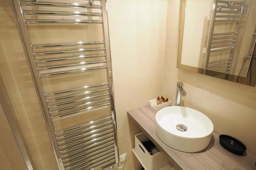 ein Badezimmer mit einem weißen Waschbecken und einer Dusche in der Unterkunft Saint germain cosy in Paris