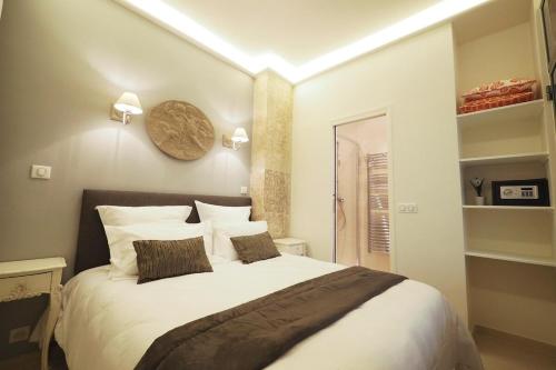 ein Schlafzimmer mit einem großen weißen Bett mit Kissen in der Unterkunft Saint germain cosy in Paris