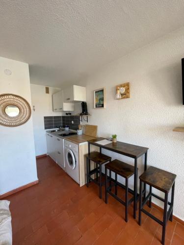 uma pequena cozinha com uma mesa e um fogão em Studio de vacances 3eme et dernier étage vue Marina em Le Barcarès
