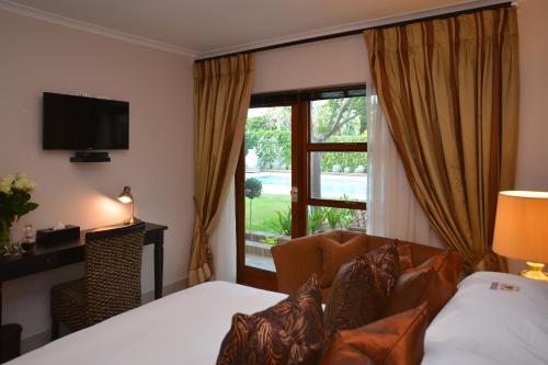 a hotel room with a bed and a window at Ridgeworth Boutique Guesthouse in Bellville