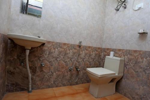 a bathroom with a toilet and a sink at Hotel Airport Plaza near Airport in New Delhi