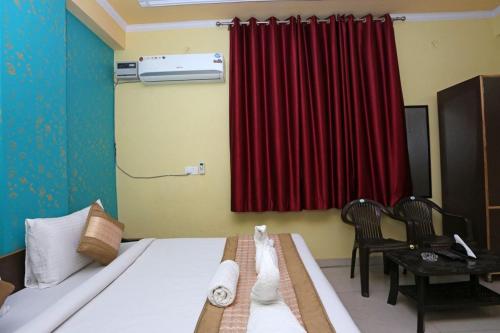 a bedroom with a bed and a red curtain at Hotel Airport Plaza near Airport in New Delhi