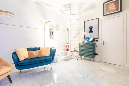 ein Wohnzimmer mit einem blauen Stuhl und einer Tür in der Unterkunft Monte Napoleone Split-level Terrace Apartment - Top Collection in Mailand