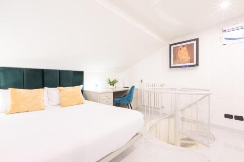 ein weißes Schlafzimmer mit einem Bett und einem Schreibtisch in der Unterkunft Monte Napoleone Split-level Terrace Apartment - Top Collection in Mailand
