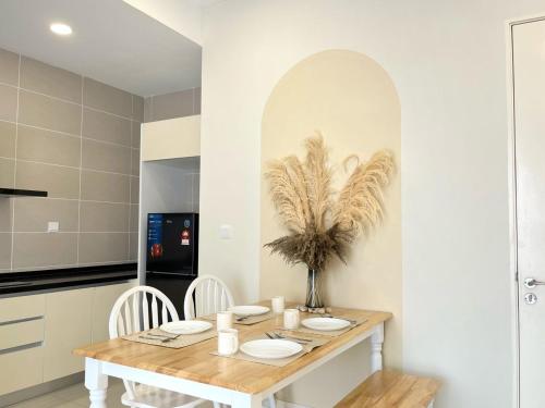 a dining room with a wooden table and chairs at D'pristine by Antlerzone in Johor Bahru