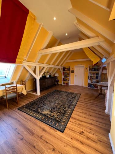 an attic room with a rug on a wooden floor at Hotel Stadtresidenz in Hildesheim