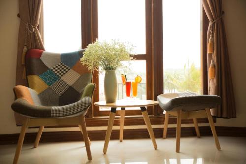 two chairs and a table in front of a window at Phong Nha Lake House Resort in Phong Nha