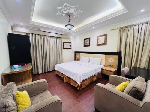 Habitación de hotel con 1 cama y 2 sofás en بوابة الريادة, en Ar Riḩāb