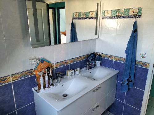 y baño con lavabo y espejo. en Sous le pommier, en Douvres-la-Délivrande