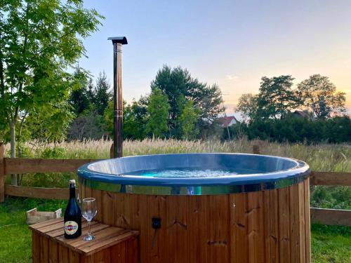a hot tub with a bottle of wine and a glass at Wypoczynkowo Domki Letniskowe in Mikołajki