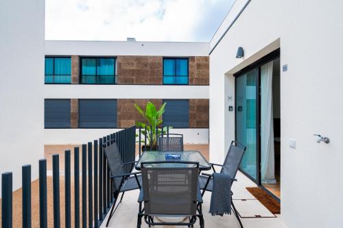 a patio with a table and chairs on a balcony at Compromisso 25 in Faro