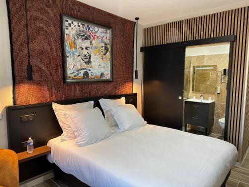 a bedroom with a white bed with a mirror and a sink at Logis Au Vieux Morvan "fait peau neuve" in Château-Chinon