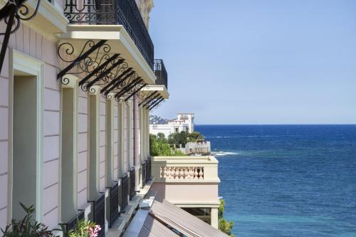 budynek z balkonem z widokiem na ocean w obiekcie Hotel Royal-Riviera w mieście Saint-Jean-Cap-Ferrat