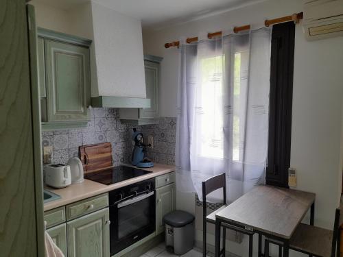 une petite cuisine avec une table et une cuisinière dans l'établissement Maison de montagne avec jardin privatif, à Sarrancolin