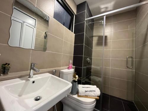a bathroom with a sink and a toilet and a mirror at D'pristine by Antlerzone in Johor Bahru