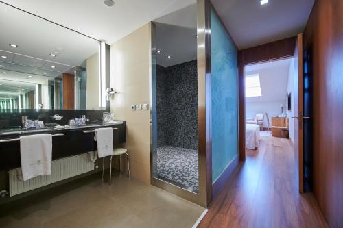 a bathroom with a shower and a large mirror at Gran Hotel La Perla in Pamplona