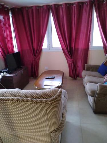 a living room with red curtains and a couch at Moradia Lili in Ronqueira