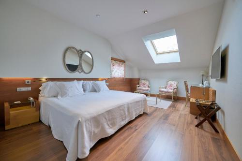 1 dormitorio con 1 cama blanca grande y espejo en Gran Hotel La Perla, en Pamplona