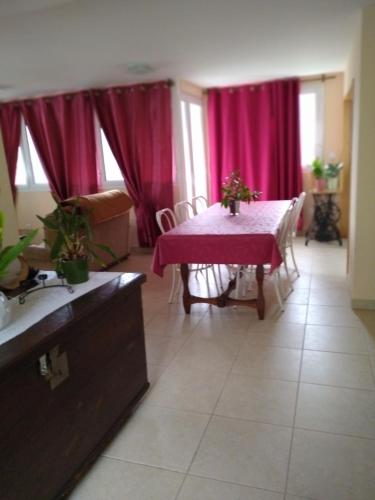 a living room with a table with a pink table cloth at Moradia Lili in Ronqueira