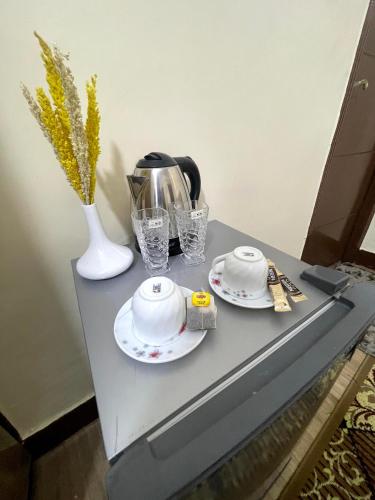 a table with two plates and a tea kettle and glasses at نزله البطران in Cairo