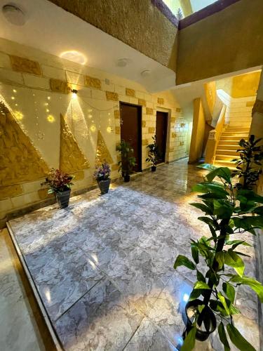 a lobby with a large marble floor with potted plants at نزله البطران in Cairo