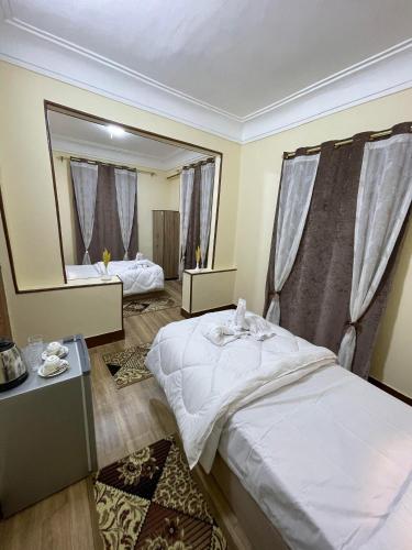 1 dormitorio con 2 camas y un espejo grande en نزله البطران en El Cairo