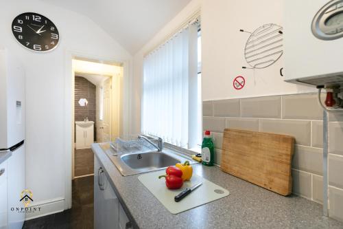 uma cozinha com um lavatório e uma bancada em OnPoint - Spacious 4 Bed House em Hanley