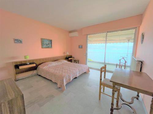une chambre avec un lit et une grande fenêtre dans l'établissement Appartement vue mer Carmino Ajaccio, à Ajaccio