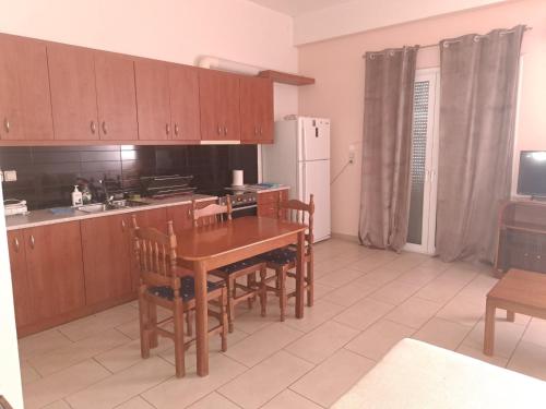 eine Küche mit einem Tisch und Stühlen sowie einem Kühlschrank in der Unterkunft warm home in Koropi