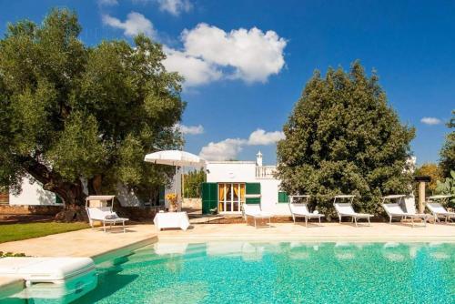 una piscina con sillas y una casa en Masseria Terramare, en Macchia di Monte