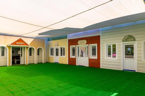 a building with a green lawn in front of it at Labranda Ephesus Princess - All Inclusive in Kusadası