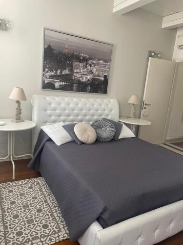 a bedroom with a white bed and two tables at La Suite di Giulia in Ferrara