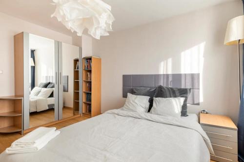 a bedroom with a large white bed and a mirror at 2BDR Duplex Apartment with Parking in Sofia
